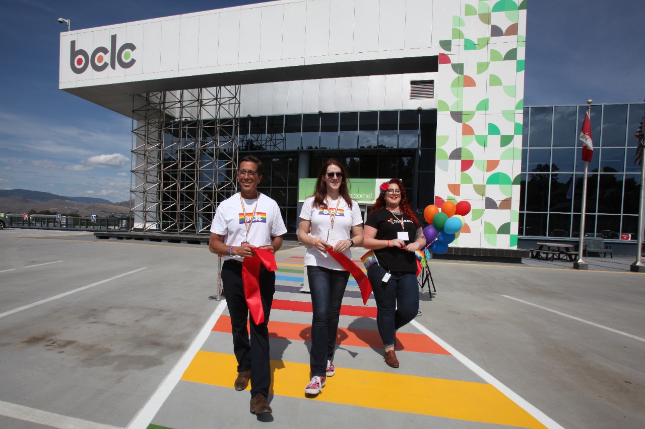 3 people walking on PRIDE crosswalk