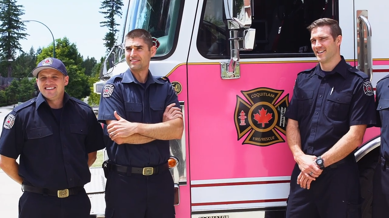 3 firefighters casually standing in front of their firetruck