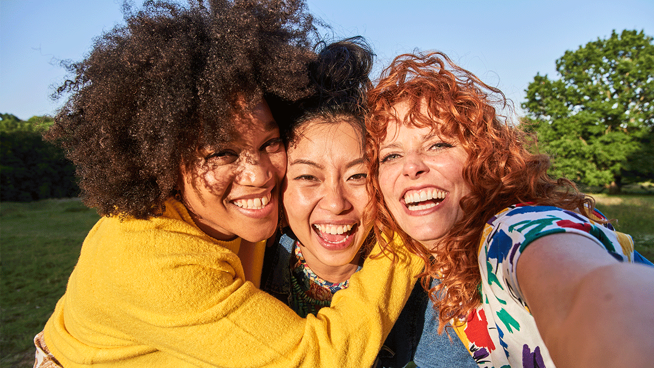Three women hugging in a park