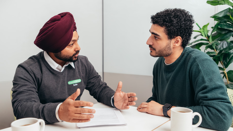 A GameSense Advisor sits at a table with a player